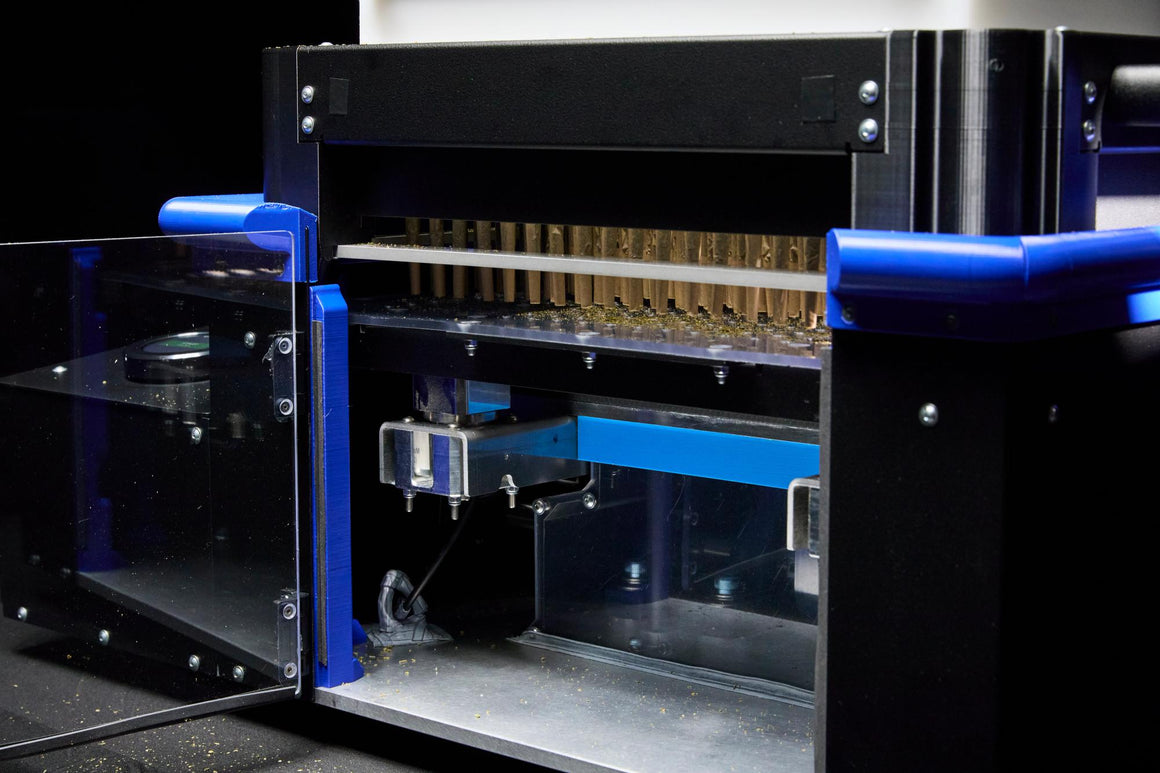 Close-up of a robotic filling and packaging machine for cannabis pre-rolls.