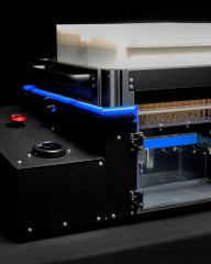 Robotic packaging machine with blue LED lighting and white product stack.