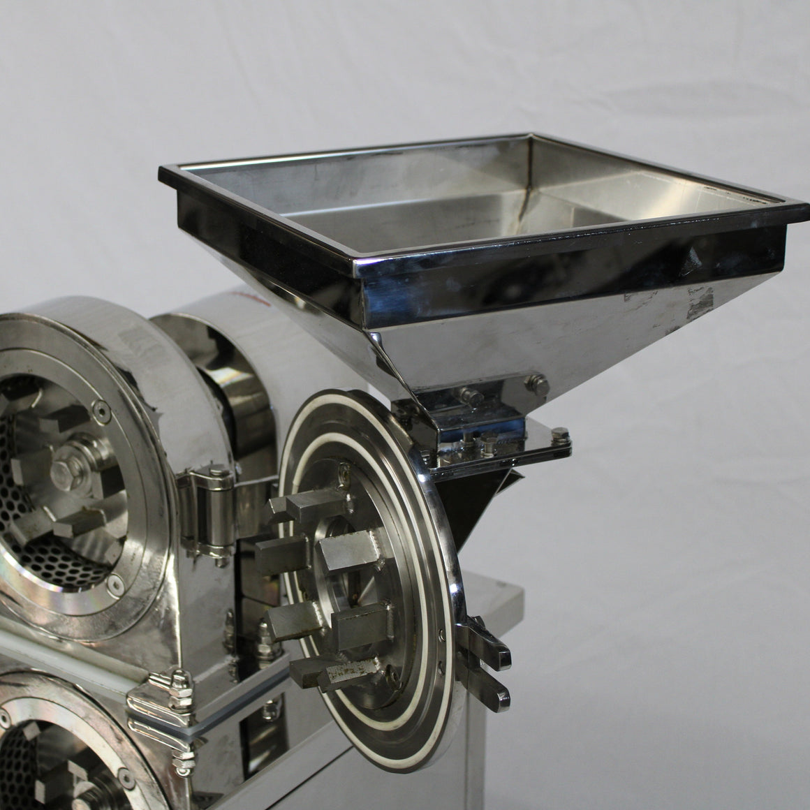 Shiny stainless steel commercial pre-roll grinder with a square hopper and rotating blades.