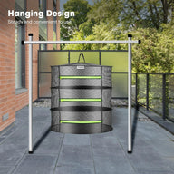 VIVOSUN mesh drying rack hanging from a silver metal stand on a patio with trees and greenery in the background.