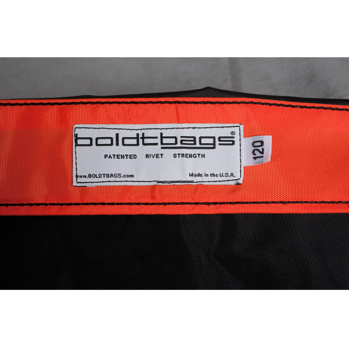 Orange and black boldtbags with a tag saying "boldtbags patented rivet strength made in the U.S.A. 120".
