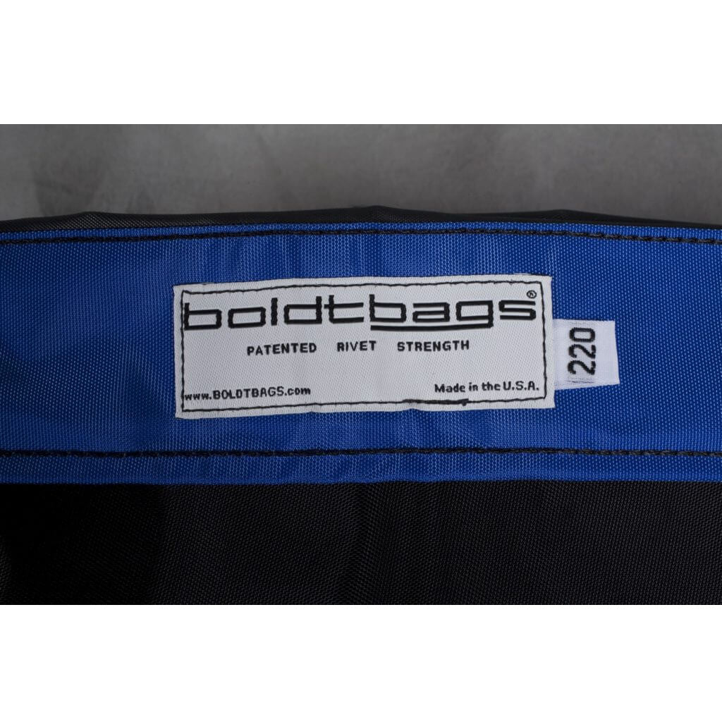 Boldtbags label on a blue and black bag, featuring "PATENTED RIVET STRENGTH" and "Made in the U.S.A.".
