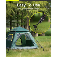 A green tent in a grassy field with a close-up of a rope tie-down mechanism.