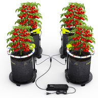 Four bushy tomato plants laden with red fruit are shown, each in a fabric pot with a circular LED grow light.