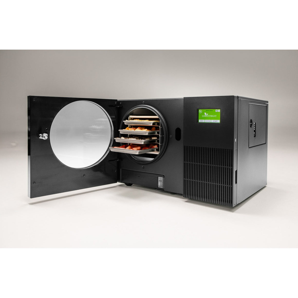 Black Countertop 360 freeze dryer with the door swung open, showing four trays of food in the chamber