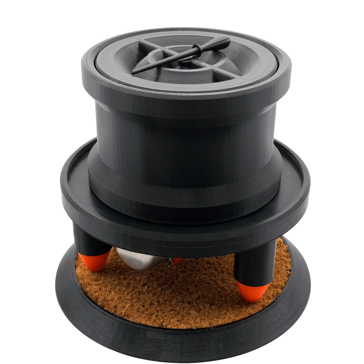 Black Humboldt cone filling machine: cylinder with a cross-patterned top, orange-tipped legs, and silver sphere on a brown mat.