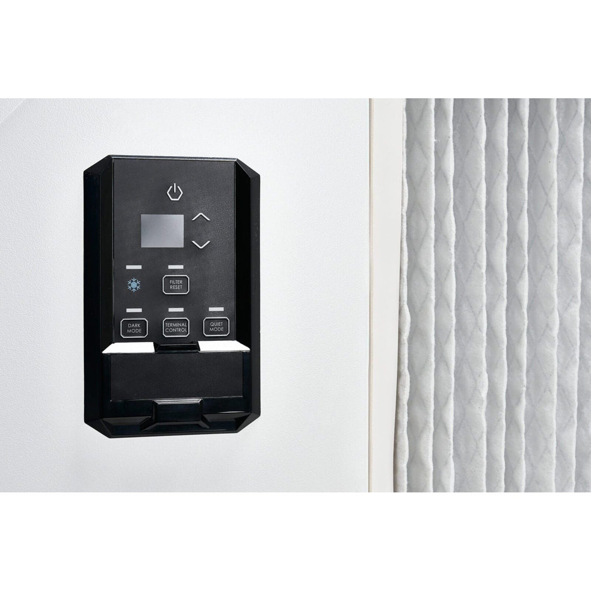 Black dehumidifier control panel with power, filter reset, and mode buttons next to a pleated air filter.